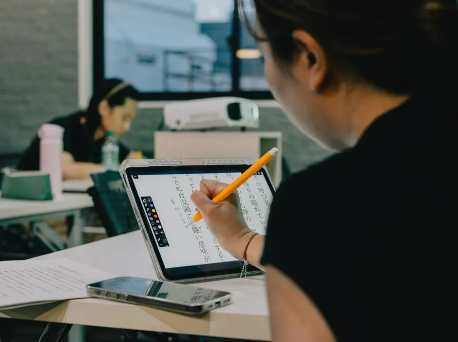 Students using laptops and tablets together in a classroom