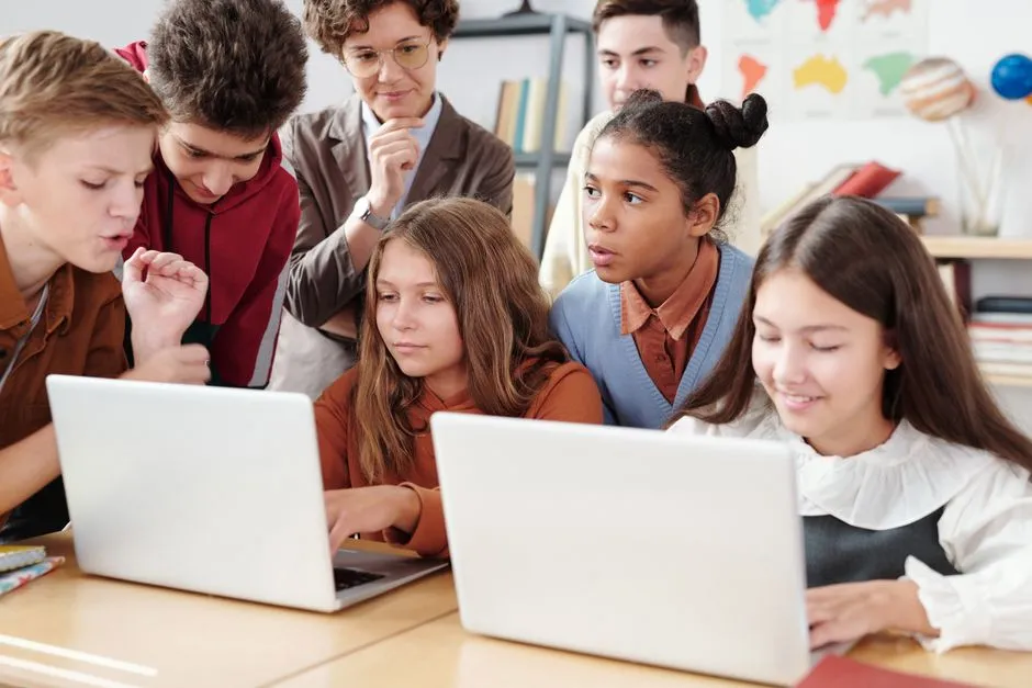 Two students sharing a laptop at a classroom desk